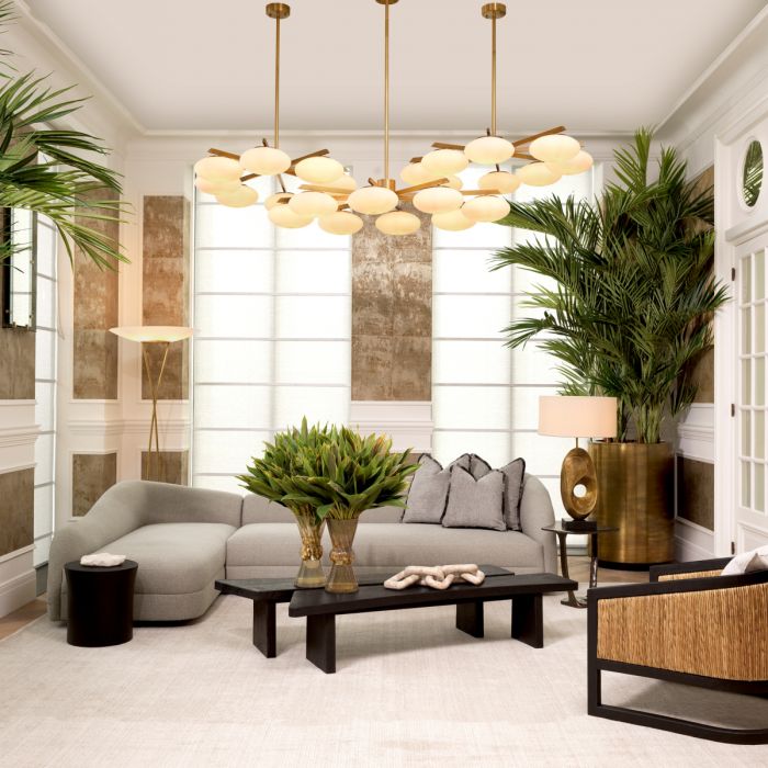 Modern living room with stylish sofa, elegant lighting, and lush greenery accents.