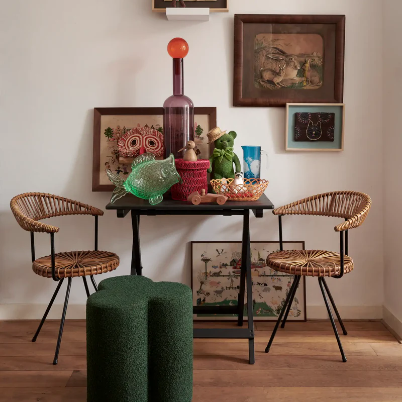 Clover haki yeşili yuvarlak puf, rattan sandalyelerle dekore edilmiş modern masa ile birlikte görüldü.