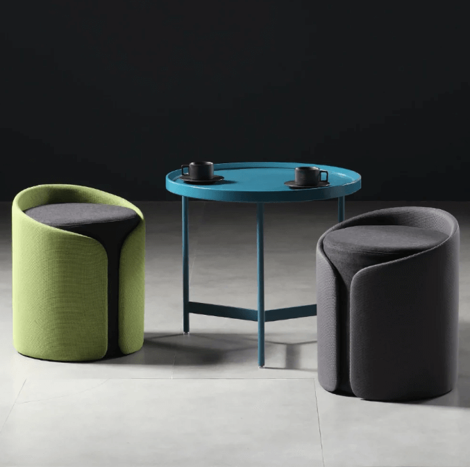 Yeşil ve gri kavisli yuvarlak mini puflar, mavi masa ile modern oturma alanı dekorasyonu.