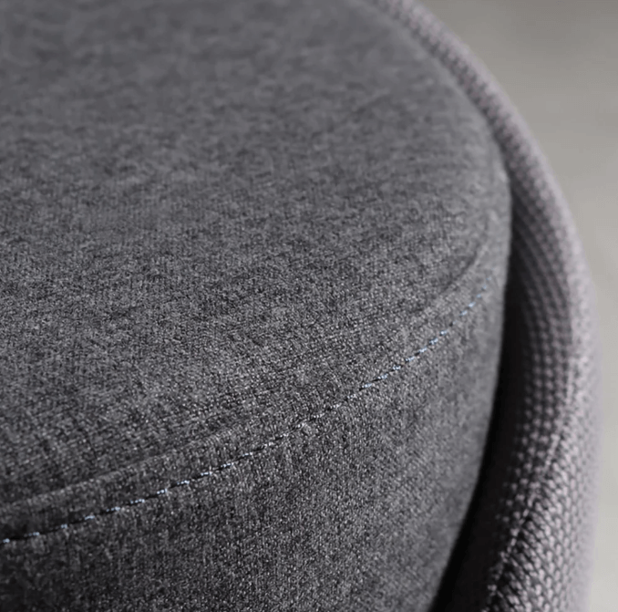 Close-up of a grey fabric mini pouf, showcasing soft, textured surface and stitched detail.