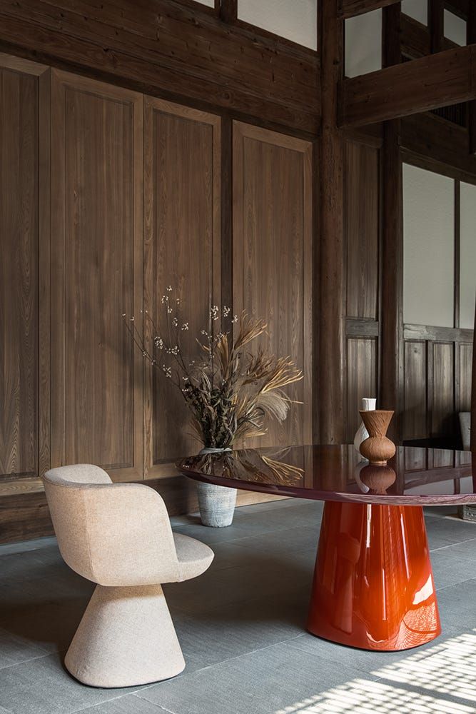 Stylish conic leg chair with textured fabric next to a modern table in an elegantly designed room.