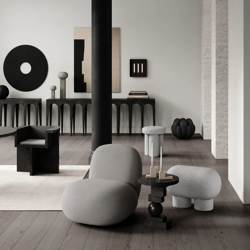 Modern living room with a gray teddy fabric round pouf, black furniture, and minimalistic decor.