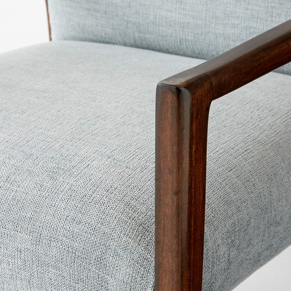 Ceviz rengi ahşap kollu sandalye, gri keten kumaş detayı ve modern tasarımlı oturum.