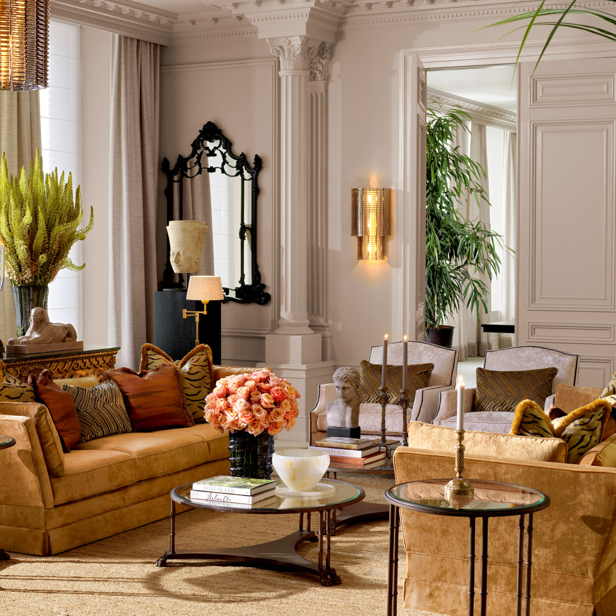 Modern living room featuring a stylish sofa, accent chairs, decorative flowers, and elegant decor elements.