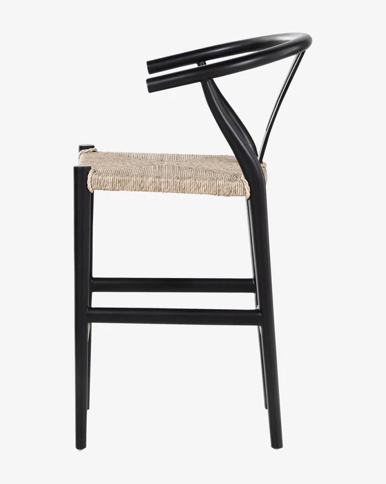 Wishbone natural wood bar stool with a minimalist design, featuring a woven seat and black frame, side view.