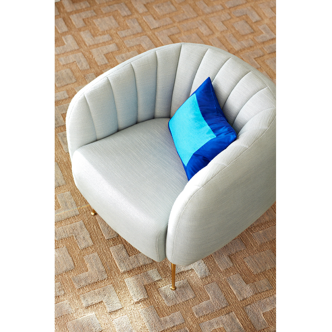 Captain Açık Gri Keten Berjer, yuvarlak form, pirinç renkli metal ayak, mavi yastık ile şık oturma alanı.