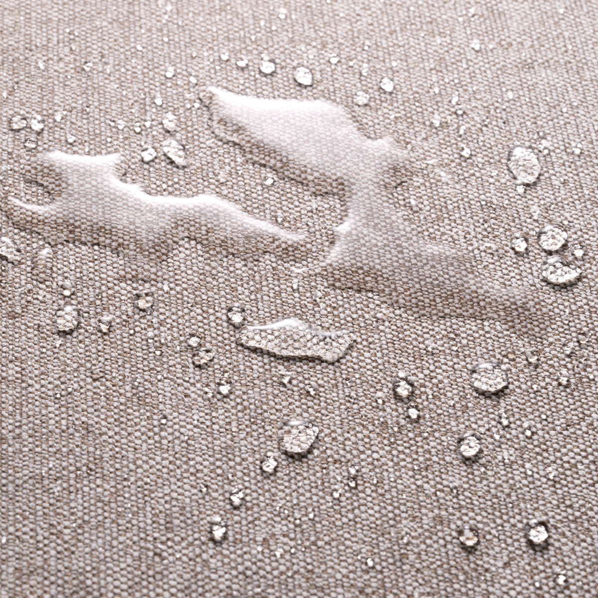 Close-up of water-resistant fabric with droplets on a textured beige surface for outdoor furniture.