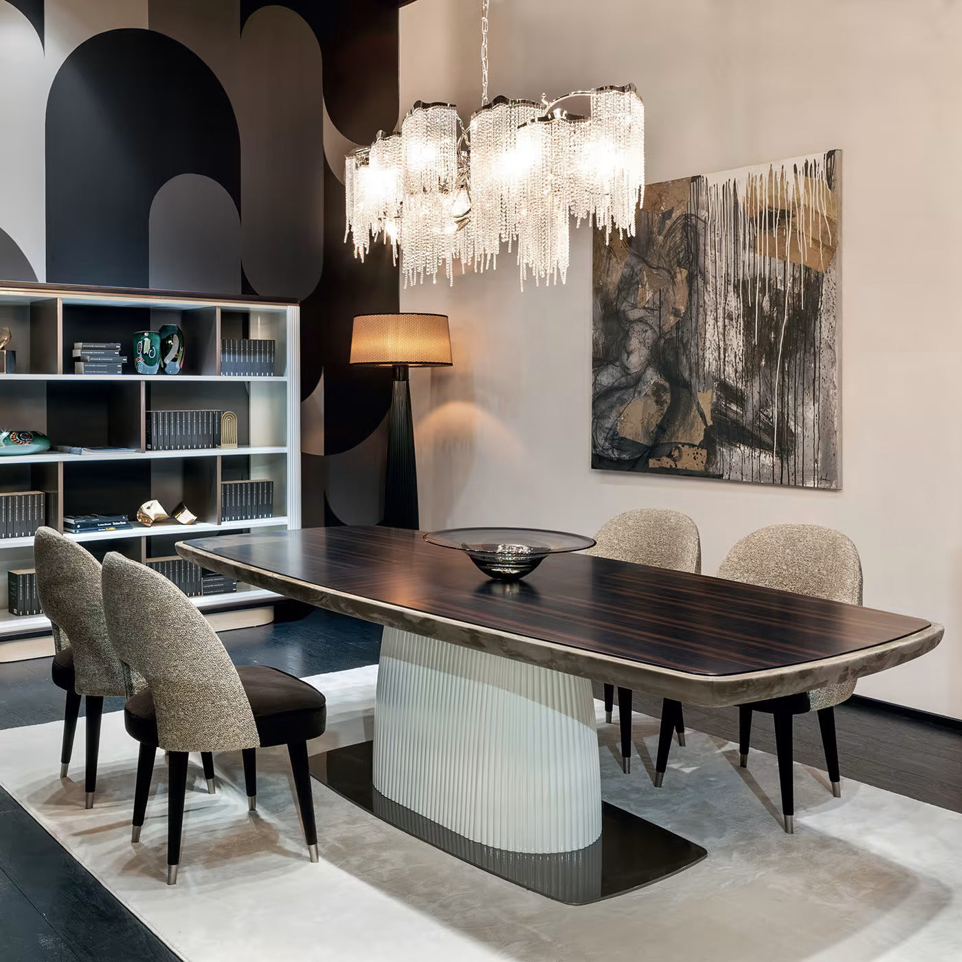 Modern dining room featuring a stylish table, plush chairs, and elegant chandelier with abstract art on the wall.