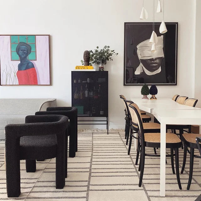 Modern living room featuring Syrah Siyah Teddy Bukle armchairs, art, and stylish dining area with black chairs.
